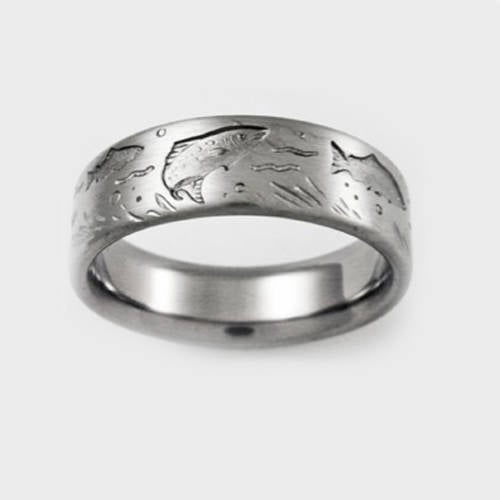 Brushed silver or titanium wedding band featuring an engraved scene of jumping fish and water ripples, centered against a plain white background