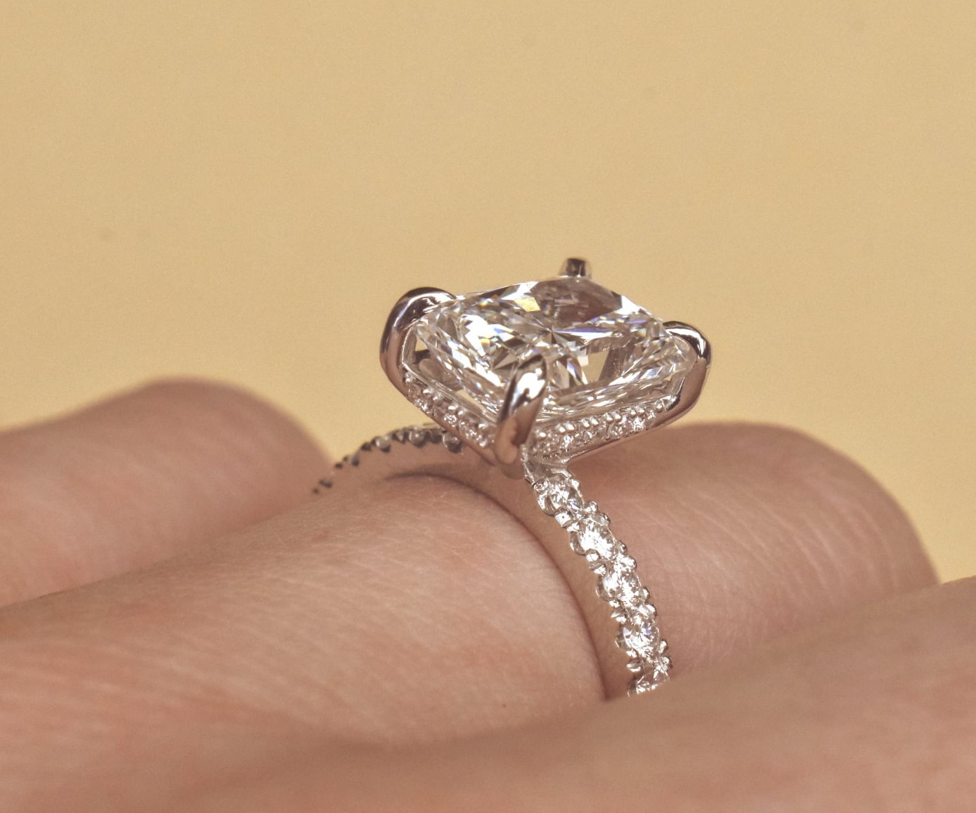 Wide gold band ring featuring a scattered cluster of various-sized round brilliant diamonds in a flush setting, reflecting on a polished surface